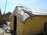 [Photo of Los Uros house with solar panel]